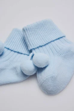 Calcetines canalé con borlas recién nacido celeste