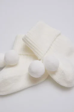 Calcetines canalé con borlas recién nacido marfil