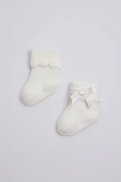 Calcetines canalé con lazo recién nacido marfil