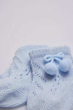 Calcetines perlé con borlas recién nacido celeste