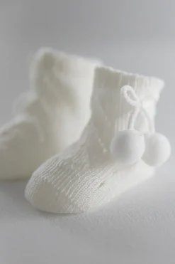 Calcetines perlé con borlas recién nacido marfil